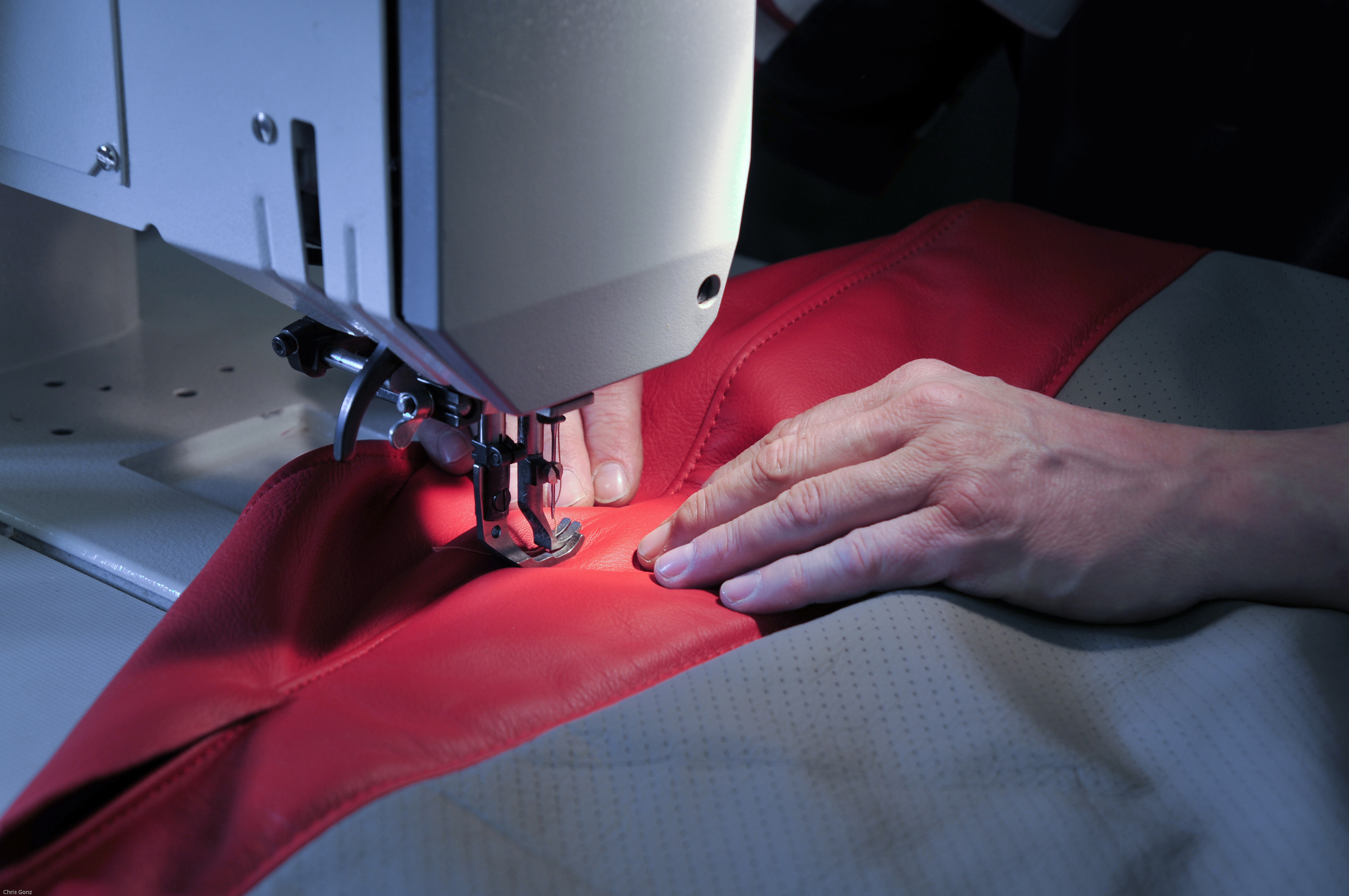 Eine Person näht Rot-Grauen Stoff